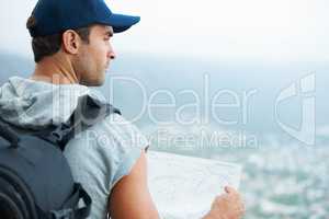 I seem to have reached the end of the road.... Young hiker holding a map and looking at the scenic view.