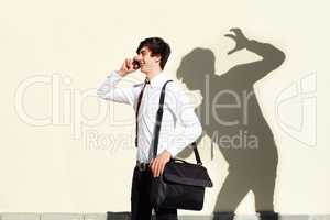 His fears are never far behind him. Shot of a young man being stalked by a ominous shadow of himself.