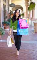 She loves to shop. Full length image of an asian woman on a shopping spree.