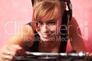 Living the dream. Closeup of a young female dj putting a record on the turntable.