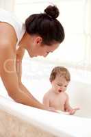 Lets get you clean and into bed. A mother washing her cute baby girl in the bath.