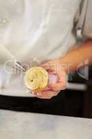 Making the perfect cupcake. A baker putting frosting on a cupcake.