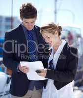 Heres the contract, all you need to do is sign.... Young businesspeople looking over some paperwork at the marina.