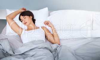 Sleepy head. Shot of a tired attractive young woman sleeping in her bed at home in the morning.