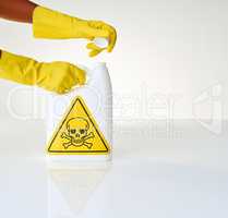 Caution - handle with care. Cropped shot of a person opening a bottle of toxic liquid against a grey background.