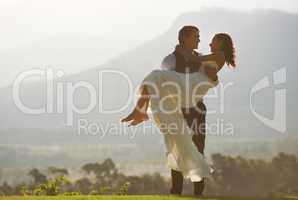 The happiest day of their lives. A groom carrying his bride.