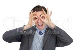 I see you. Playful image of an excited businessman pretending his hands are glasses - isolated.