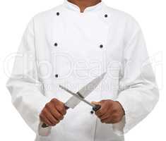 Tools of the trade. A young chef sharpening his knives while isolated on a white background.