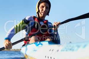 Ready to row. Shot of a young man kayaking in a river.