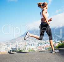 Cross country. Shot of a sporty young woman going for a run outdoors.