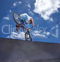 Practicing for the x games. Rearview shot of a teenage boy riding a BMX at a skatepark.