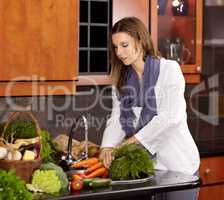 Making sure to wash her vegetables. Attractive woman washing fresh vegetables in her kitchen sink.