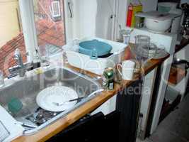 Must have been a fun night A teenagers first apartment. A messy kitchen following a late night.