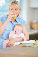 Mommy and baby need their sustenance. A mother and her adorable baby girl sitting in the kitchen enjoying breakfast.