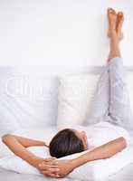 Morning relaxation. Rearview shot of a young woman sleep with her legs propped up on a pillow.