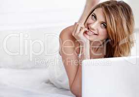 Naturally gorgeous. Portrait of an attractive young woman using a laptop while lying down on the floor in her bedroom.