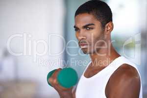 This is his time to tone. A fitness shot of a young man toning with weights.