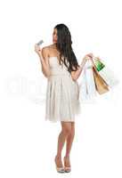 Going shopping with plenty of credit. Studio shot of an attractive young woman in a cocktail dress holding shopping bags and a credit card against a white background.