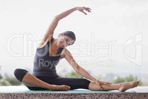Yoga is a way of life. Portrait of a young woman doing yoga stretches on her patio.