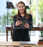 Be a smart business owner. Portrait of a young business owner using a digital tablet in her clothing store.