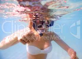 Im ready to explore the ocean. Portrait of a young woman in snorkeling gear giving the thumbs up sign underwater.
