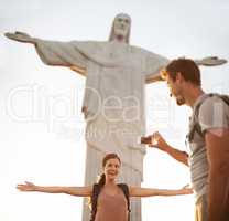 Stay right like that..... Shot of a happy young couple taking photos at the Christ the Redeemer statue.