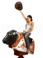 Yeehaw. Studio shot of a beautiful young woman riding a mechanical bull against a white background.