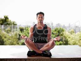 Seeking inner strength to match his outer strength. Full length shot of a man meditating in the lotus position.