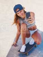 Summertime is selfie time. Shot of a young skater taking at selfie at the beach.