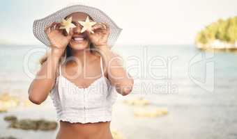 Feeling like a star today. Cropped shot of an attractive young woman standing and playfully holding up star shaped pineapple pieces against her eyes.