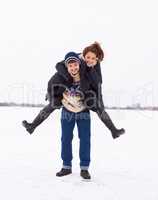 Loving this weather. A cute young couple being playful in on the ice of a frozen natural lake.