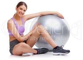 Youre only one workout away from a good mood. Portrait of a young woman sitting next to her fitness ball.