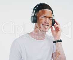 Where words fail, music speaks. Portrait shot of a handsome young man with vitiligo listening to music with wireless headphone on a white background.