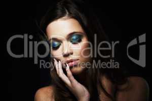 Bright eyeshadows create a dramatic look. Shot of a beautiful young woman with her eyes closed and dramatic makeup.