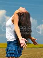 The only place where my spirit can soar. Shot of a beautiful young woman standing in the countryside with her arms opened in joy.