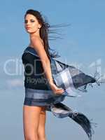 Beauty in the breeze. Shot of a beautiful young woman draped in a sarong blowing in the wind.