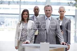 Determination has never looked so good. Portrait of a determined business team standing at a podium together.