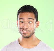 Ah duh. Cropped shot of a handsome young man making a face against a green background in studio.