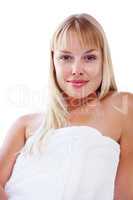 Smiling blond woman wrapped in a towel against white. Cute blond female wrapped in a bath towel against white background.