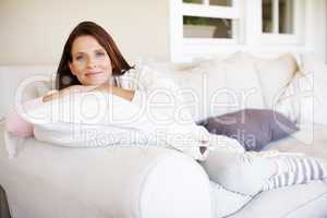 Its important to take time out. Portrait of an attractive woman lounging on a sofa indoors.