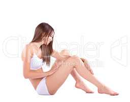 That is smooth.... Full body studio shot of a young woman caressing her bare leg.