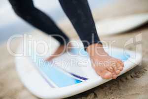 Getting a feel for the board. Cropped shot of an unrecognizable female surfers feet on a surfboard.