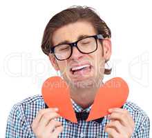 Hes heartbroken. A young man crying while holding a torn paper heart.