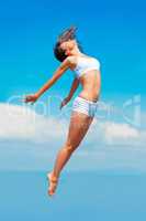 Propelled by an energy boost. A young woman in mid-air with her body outstretched.