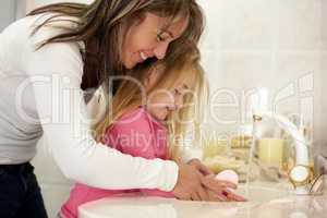 Its so important to wash your hands.... Shot of a mother teaching her daughter how to wash her hands.