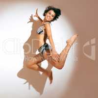 Summer is here. Studio shot of a ecstatic young woman in a bikini jumping in the air.