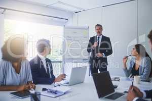 They never fail to plan hard for success. Shot of a mature businessman giving a presentation to his colleagues in an office.