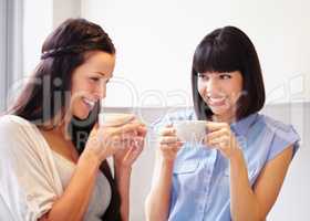 Anything can be fixed by a moment with good friend. Two women sharing an enjoyable moment in the kitchen over coffee.