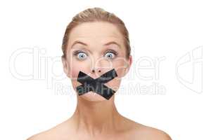 Silenced by the system. A young blonde woman looking shocked with duct tape covering her mouth.