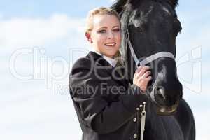 The bond between rider and horse. Low angle portrait of a young female rider hugging her horse affectionately.